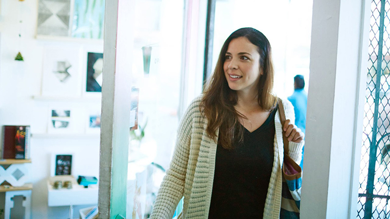 A woman traveler entering a shop.