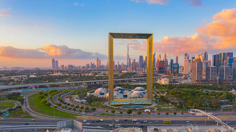 Aerial view of Dubai Frame, Downtown skyline, United Arab Emirates or UAE. Financial district and business area in smart urban city. Skyscraper and high-rise buildings at sunset.